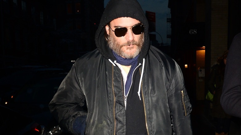 Joaquin Phoenix in hoodie and sunglasses