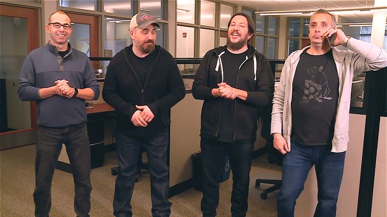 The Impractical Jokers standing in an office building 