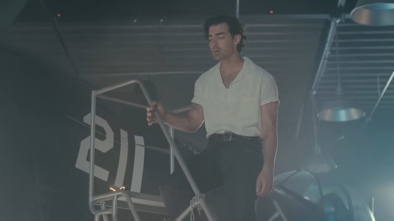 Joe Jonas singing by a plane