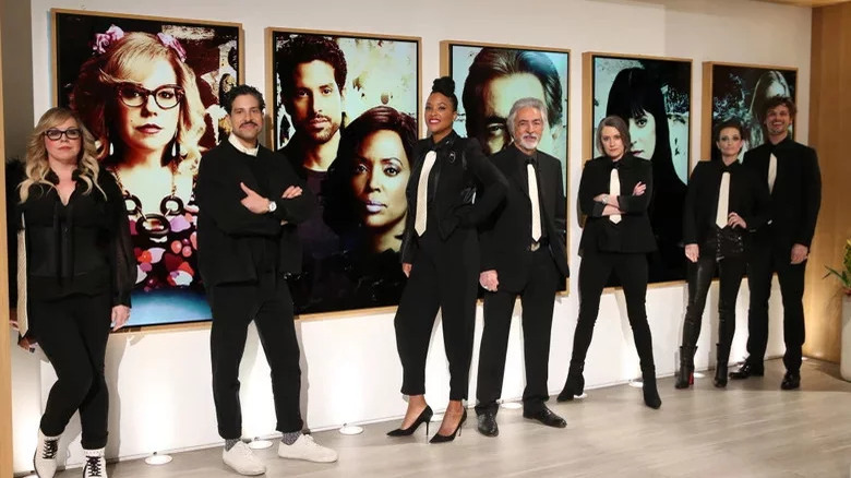 The Criminal Minds cast posing in front of portraits