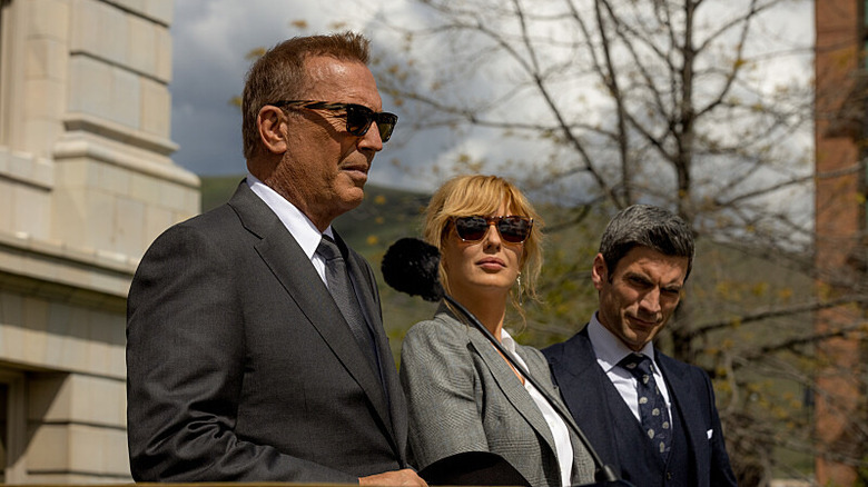 Kevin Costner as John Dutton, Kelly Reilly as Beth Dutton, and Wes Bentley as Jamie Dutton standing outside during campaign speech