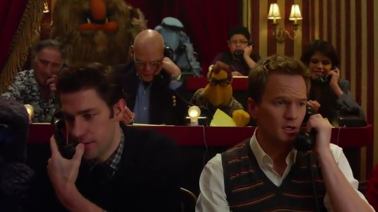 John Krasinski and Neil Patrick-Harris working a phone bank surrounded by Muppets