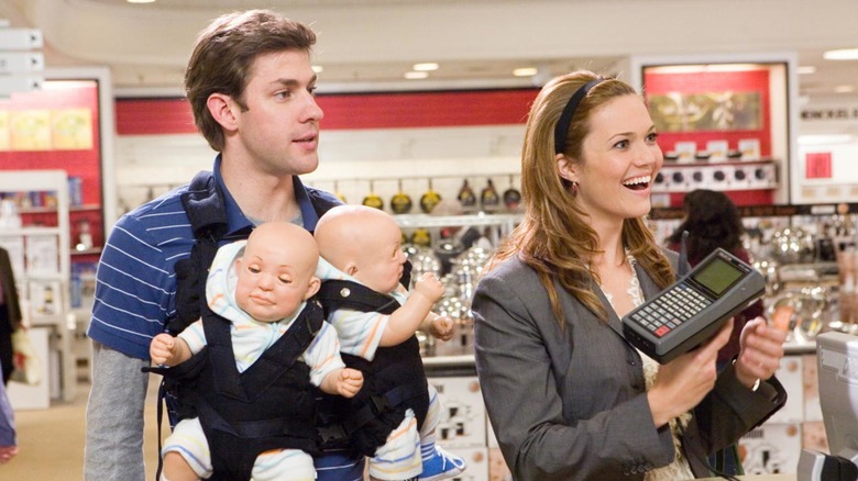 Ben and Sadie swaddling two robot babies in a department store