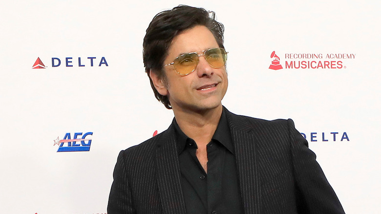 John Stamos posing in black suit