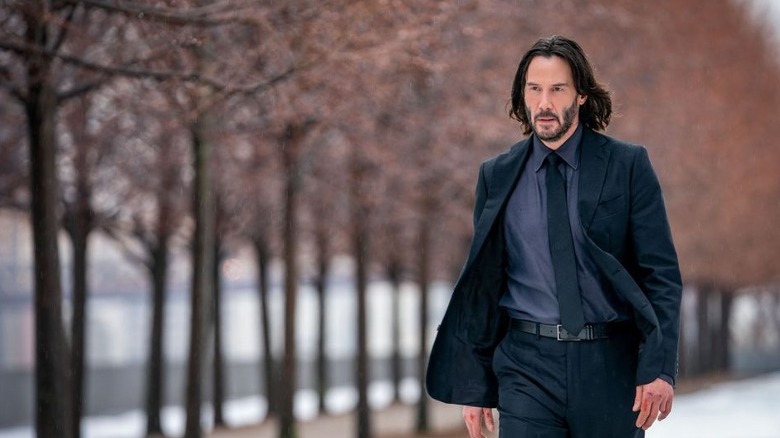 John Wick walks past trees