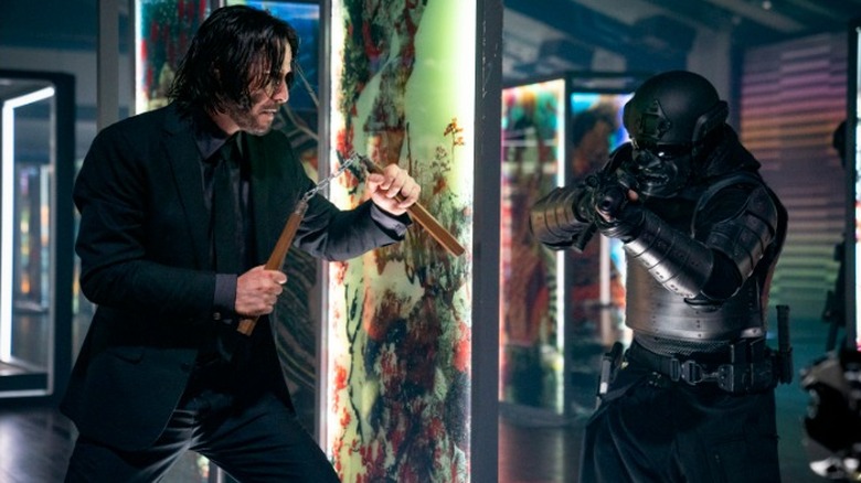 John Wick with nunchucks facing a soldier