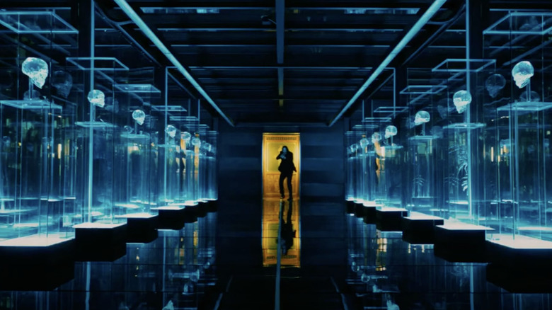 John Wick entering a row of glass cases