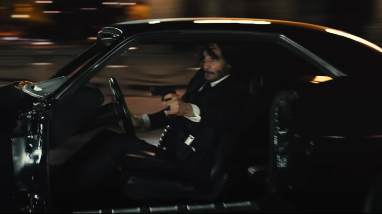 Keanu Reeves driving and shooting