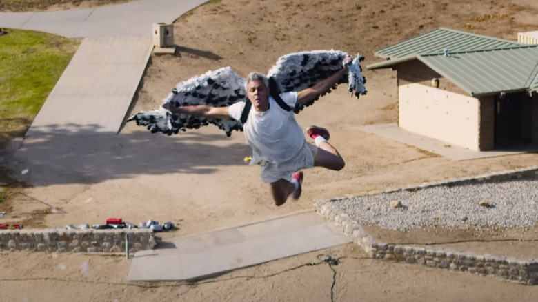 Johnny Knoxville wearing fake wings getting fired out of a cannon 