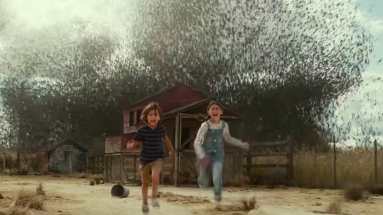 Two kids running from locusts