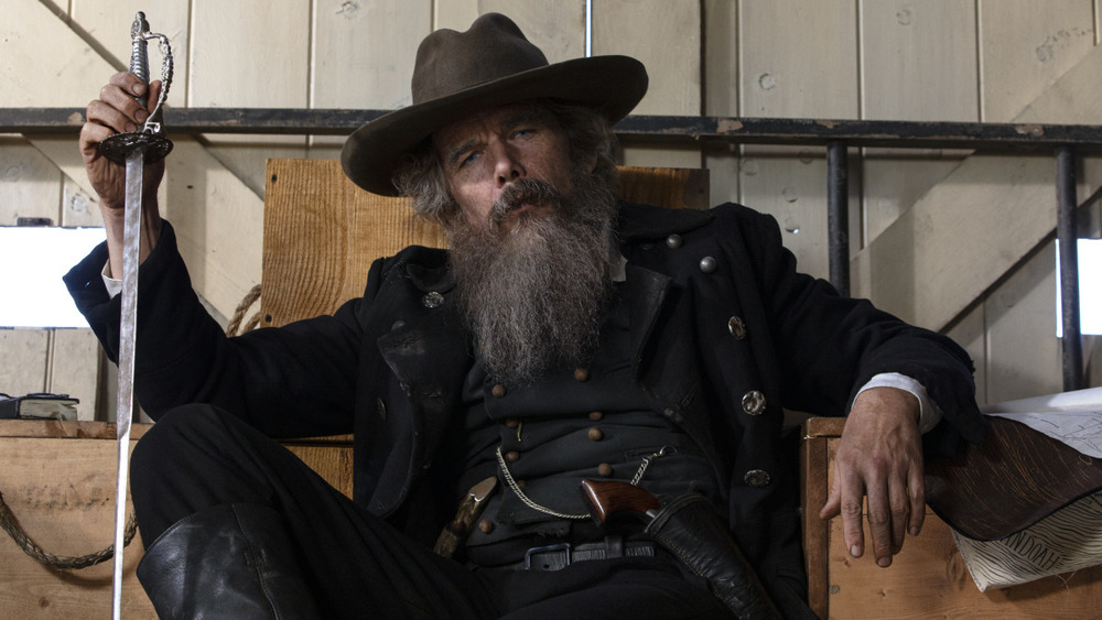 Ethan Hawke as John Brown seated holding a sword in Good Lord Bird