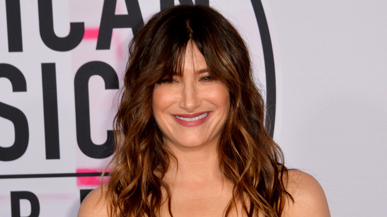 Kathryn Hahn smiling with brunette bangs 