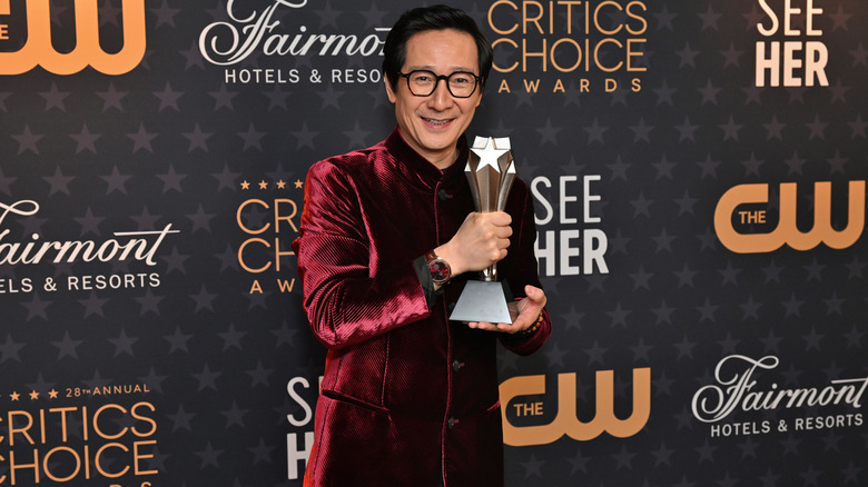 Ke Huy Quan holding his award at awards ceremony 