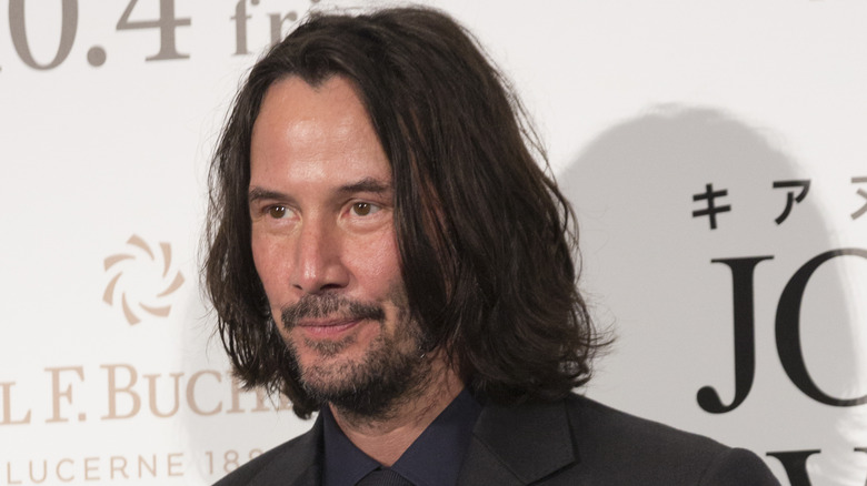 Keanu Reeves smiling beard stubble