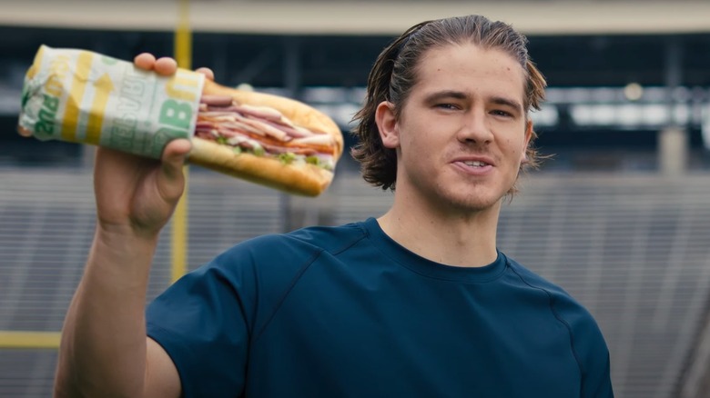 Justin Herbert holding sandwich