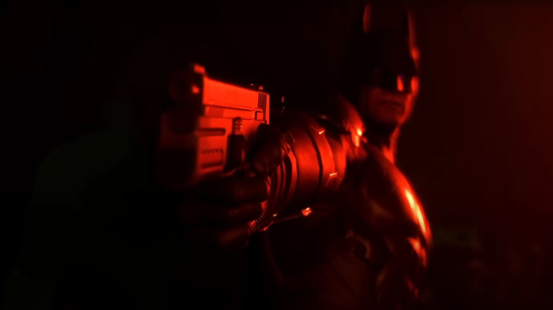 Batman aims a gun