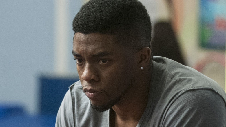 Chadwick Boseman looks down