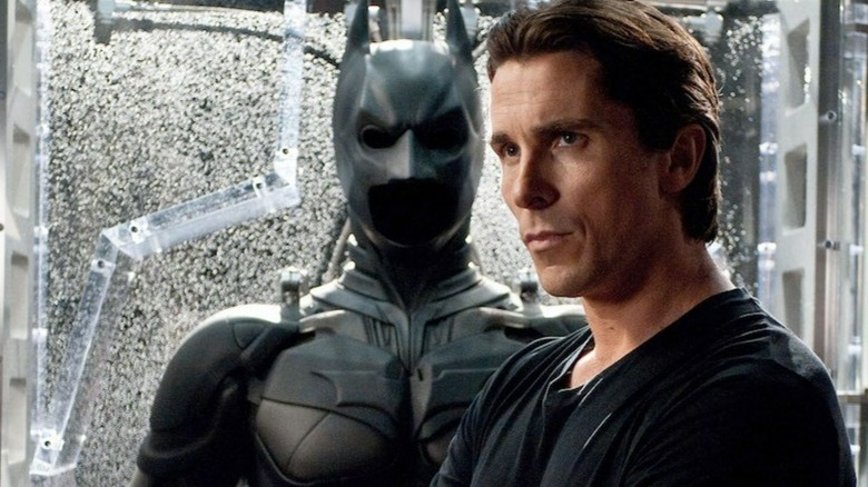 Bruce Wayne in front of his batsuit