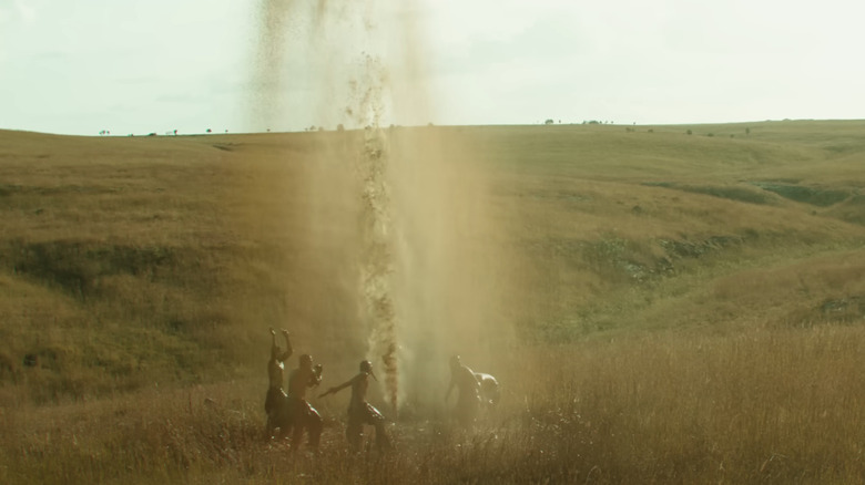 Osage tribespeople dancing around an eruption of oil in celebration 