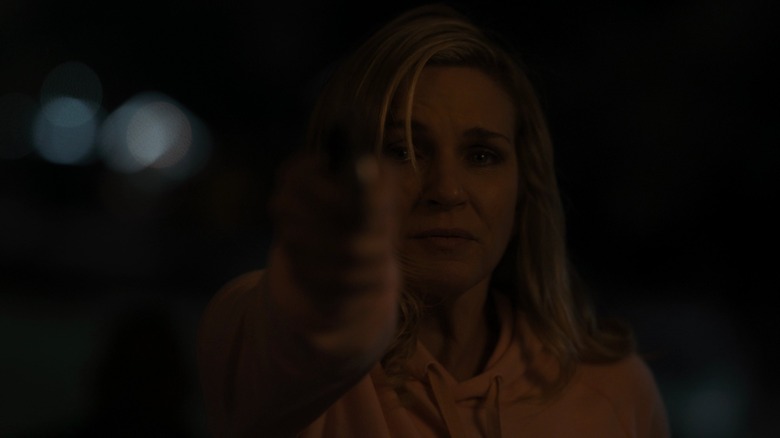 Kim aiming a gun in "Point and Shoot"