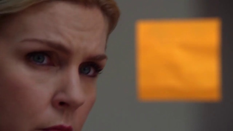 Kim looking at a Post-It note in "Rebecca"