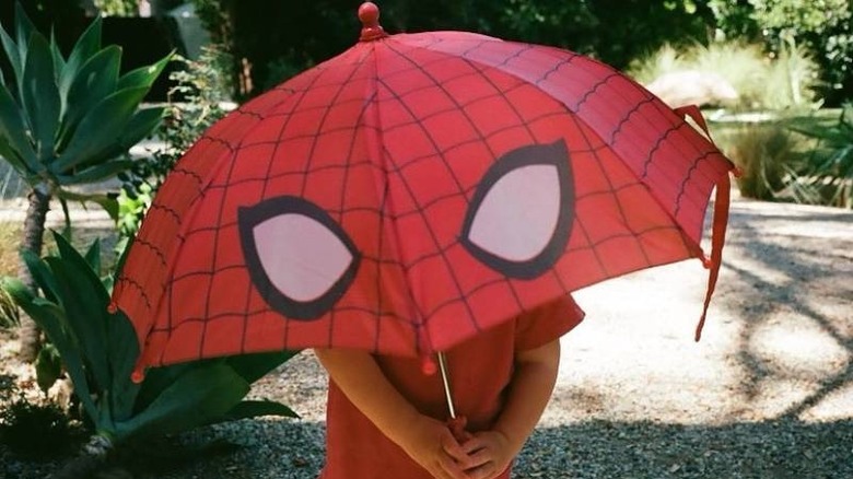 Kirsten Dunst's child holding a Spider-Man umbrella