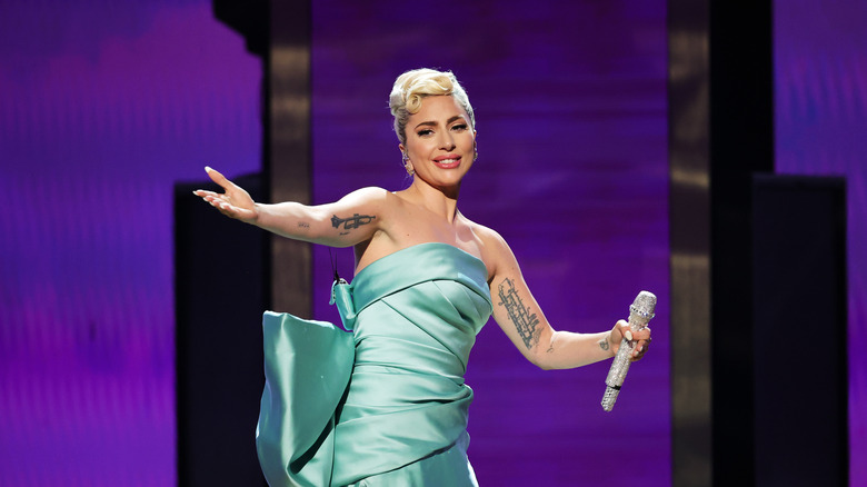 Lady Gaga smiling and holding up arms