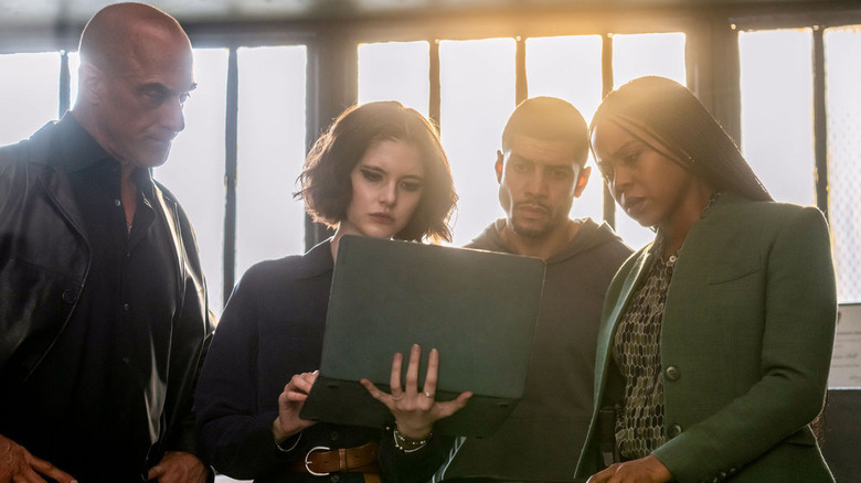 The Organized Crime crew stares at a laptop