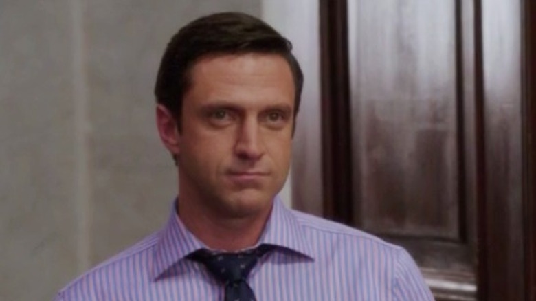 Rafael Barba standing pensively in front of an open door