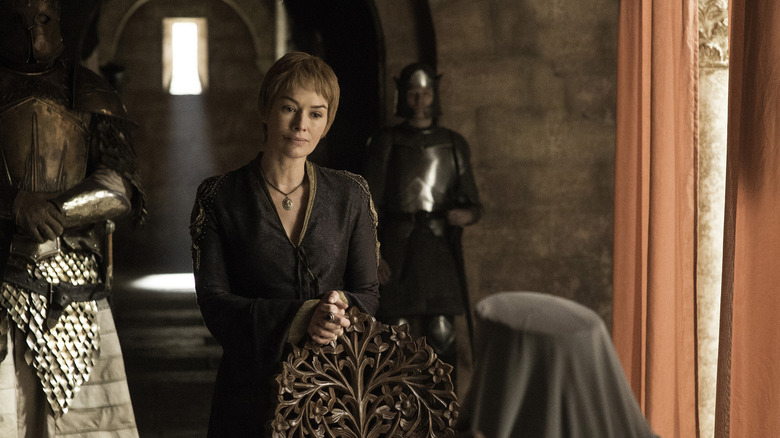 Cersei standing behind chair