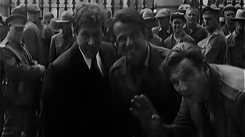 Liam Neeson waving at the camera with Aidan Quinn and Stephen Rea