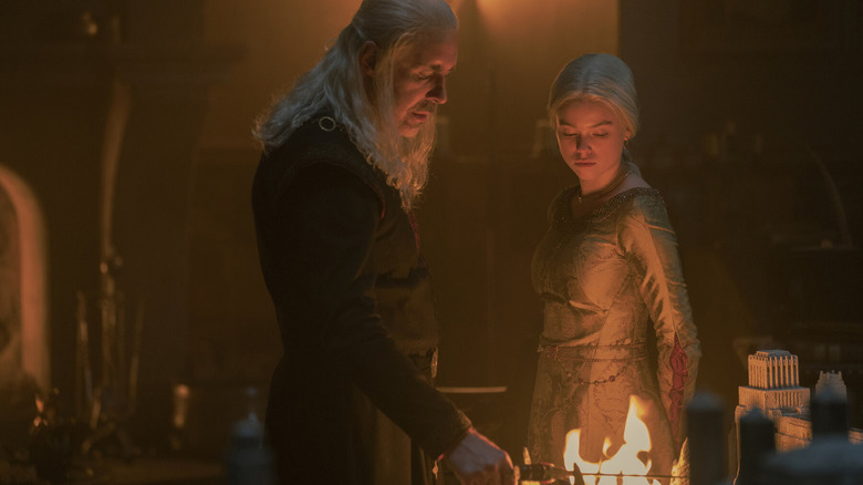 Viserys holds the dagger in flames