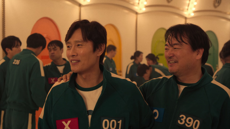 Jung-bae puts his hand on In-ho's shoulder in "Squid Game" (2024)