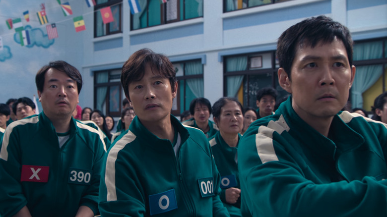 Hwang In-ho, Seong Gi-hun, and Jung-bae watch the six-legged race in "Squid Game" (2024)