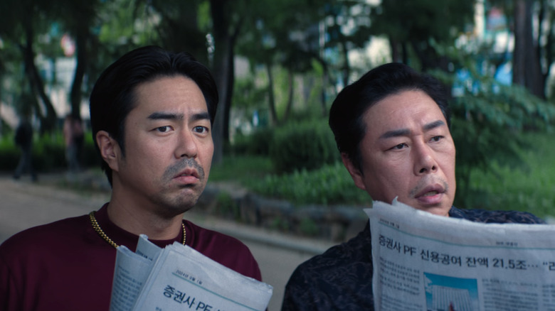 Sunshine Capital henchmen read newspapers in "Squid Game" (2024)