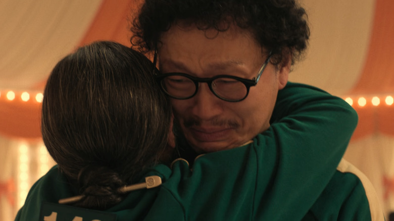 Park Yong-sik hugs Jang Geum-ja in "Squid Game" (2024)