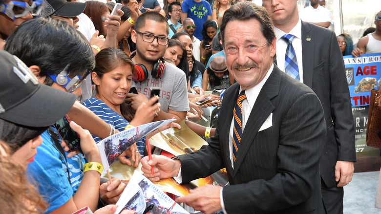 Peter Cullen smiling and signing autographs