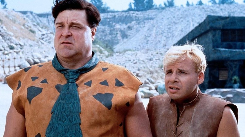 Fred Flintstone and Barney Rubble standing