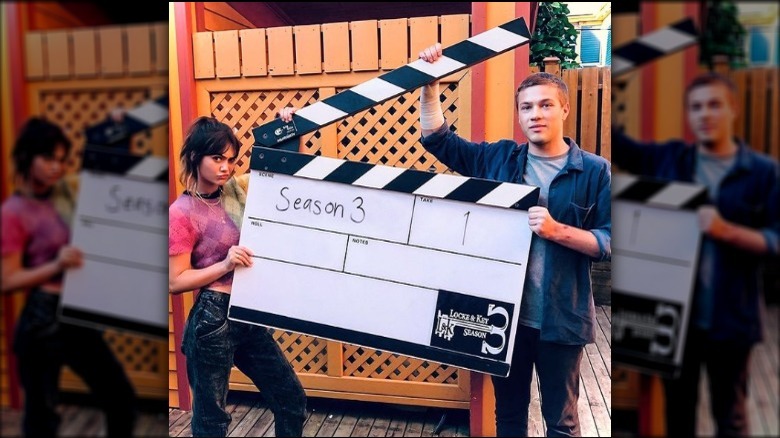 Connor Jessup and Emilia Jones holding a slate