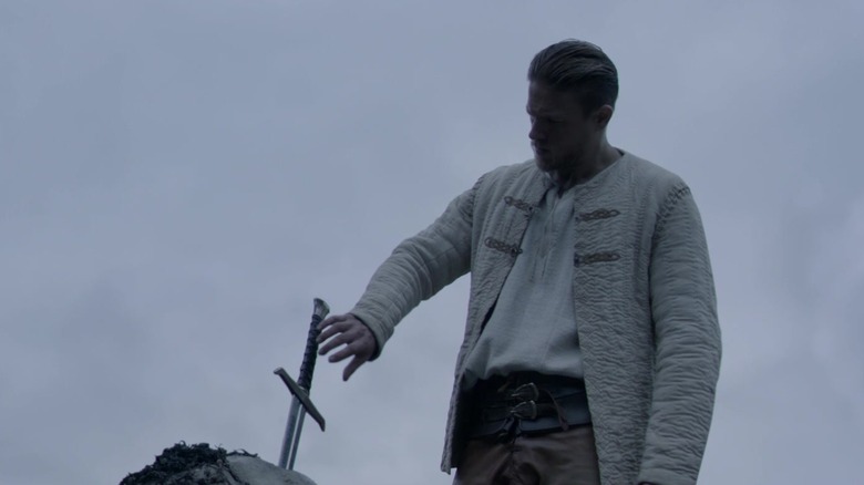 Charlie Hunnam reaching for sword