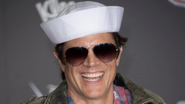 Johnny Knoxville wearing a sailor's cap and laughing