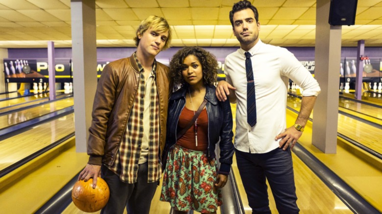 Dylan, Evie, and Lucas stand in a bowling alley on Lovesick