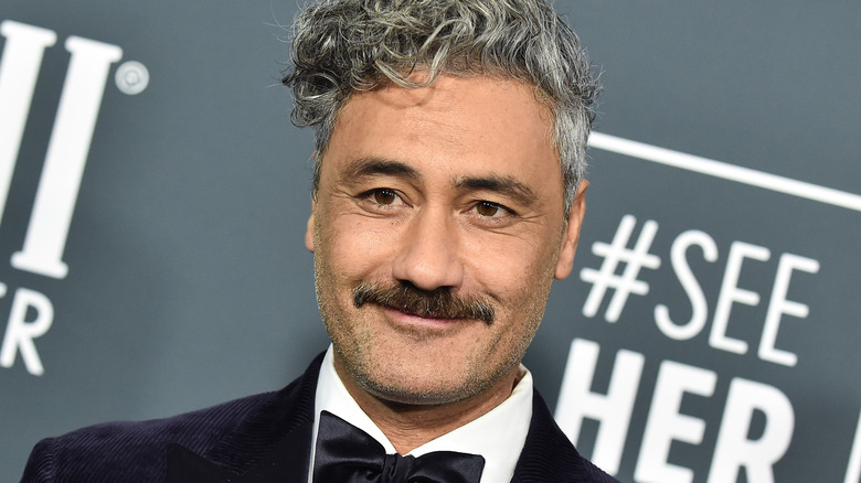 Taika Waititi smiling on the red carpet