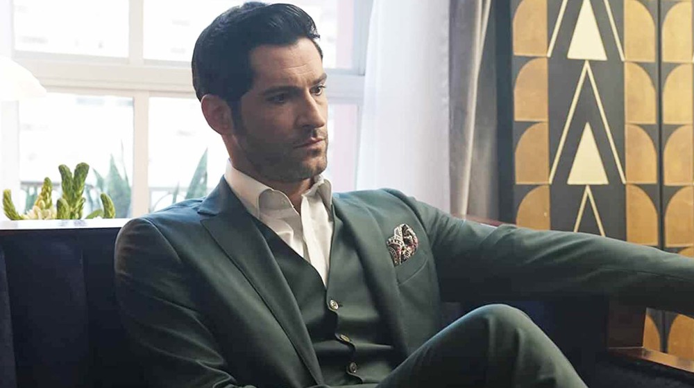 Lucifer Morningstar seated in a suit