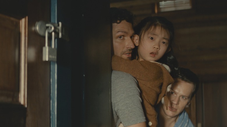 Andrew, Wen, and Eric behind door in Knock at the Cabin