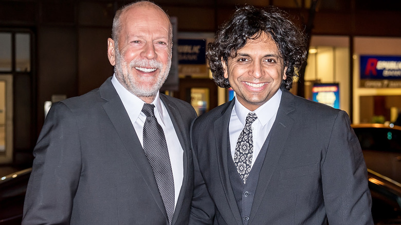 Willis and Shyamalan pose at event