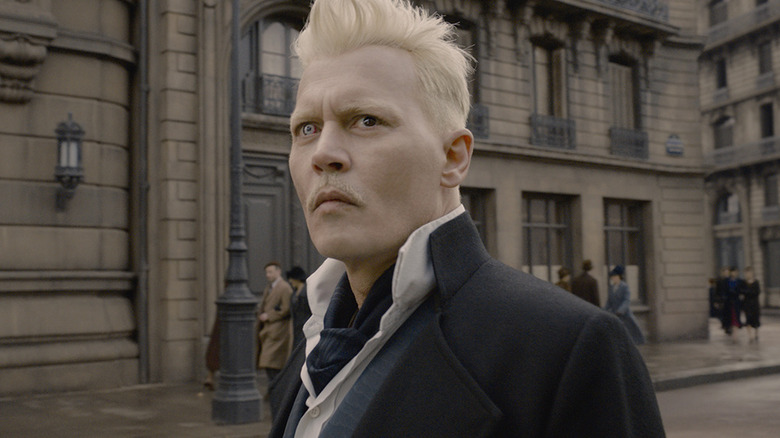 Johnny Depp as Gellert Grindelwald in front of a building