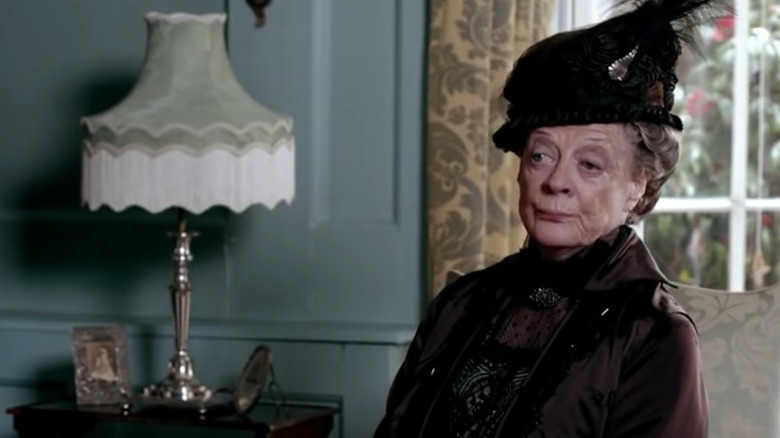 Maggie Smith smirks in a parlour