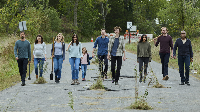 Manifest survivors walk along a road together