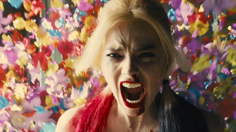 Harley Quinn yelling with flowers behind her 